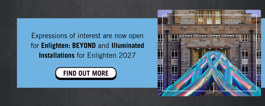 tile with text that says Expressions of interest are. now open for enlighten: beyond and illuminated installations for Enlighten 2027. A white button says 'find out more'. Next to the text is an image of a large inflatable installation in front of a building. 